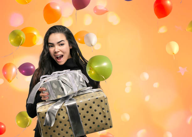 Teenage girl giving gifts with balloons